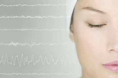 Female has her eyes closed and wearing a cap over her head during a sleep study