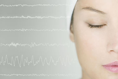 Female has her eyes closed and wearing a cap over her head during a sleep study