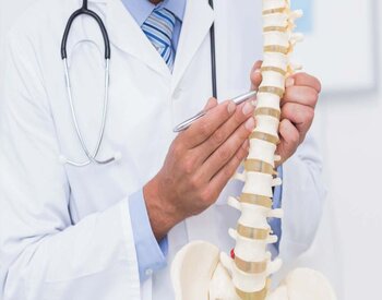 Male Physician showing a spine prop