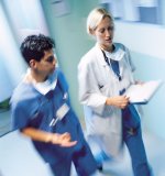 Female Physician walking with a Male Nurse in a Hospital hallway